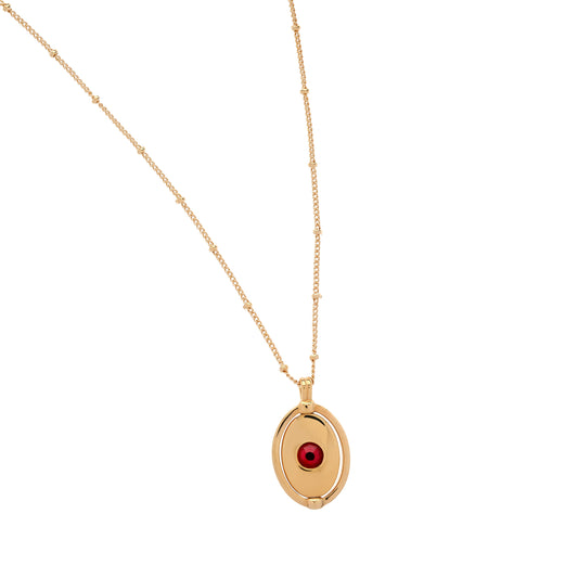 Gold necklace with a red gemstone pendant on a white background