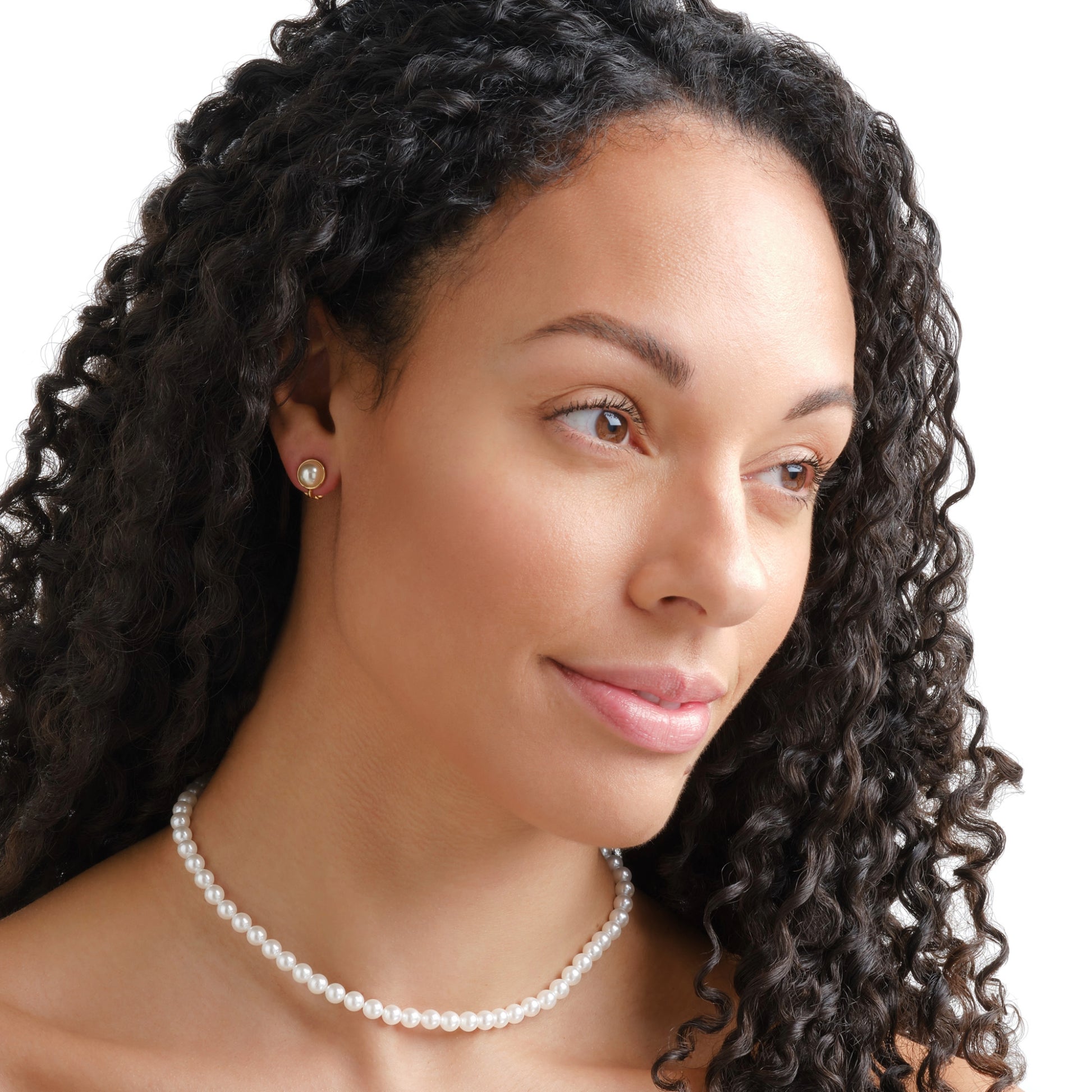 Woman with curly hair wearing a pearl necklace on a white background