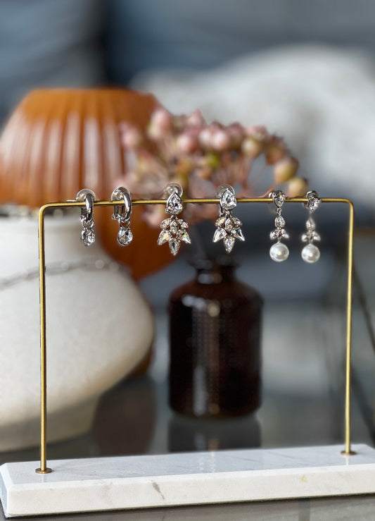Set of earrings on a gold stand with a blurred background