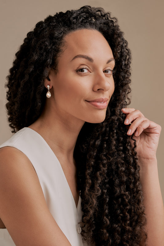 A model with Gold and Crystal Teardrop clip on Earrings