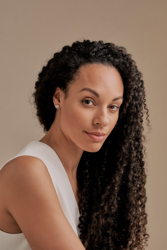 A silver and crystal stud clip on earrings on a model