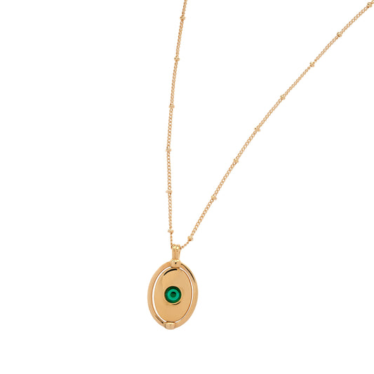 Gold necklace with a green gemstone pendant on a white background