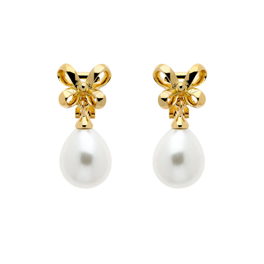 A pair of gold clip earrings featuring a bow design atop a faux pearl drop.