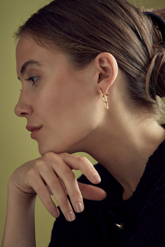 A model shot of gold plated chain designed clip on earrings