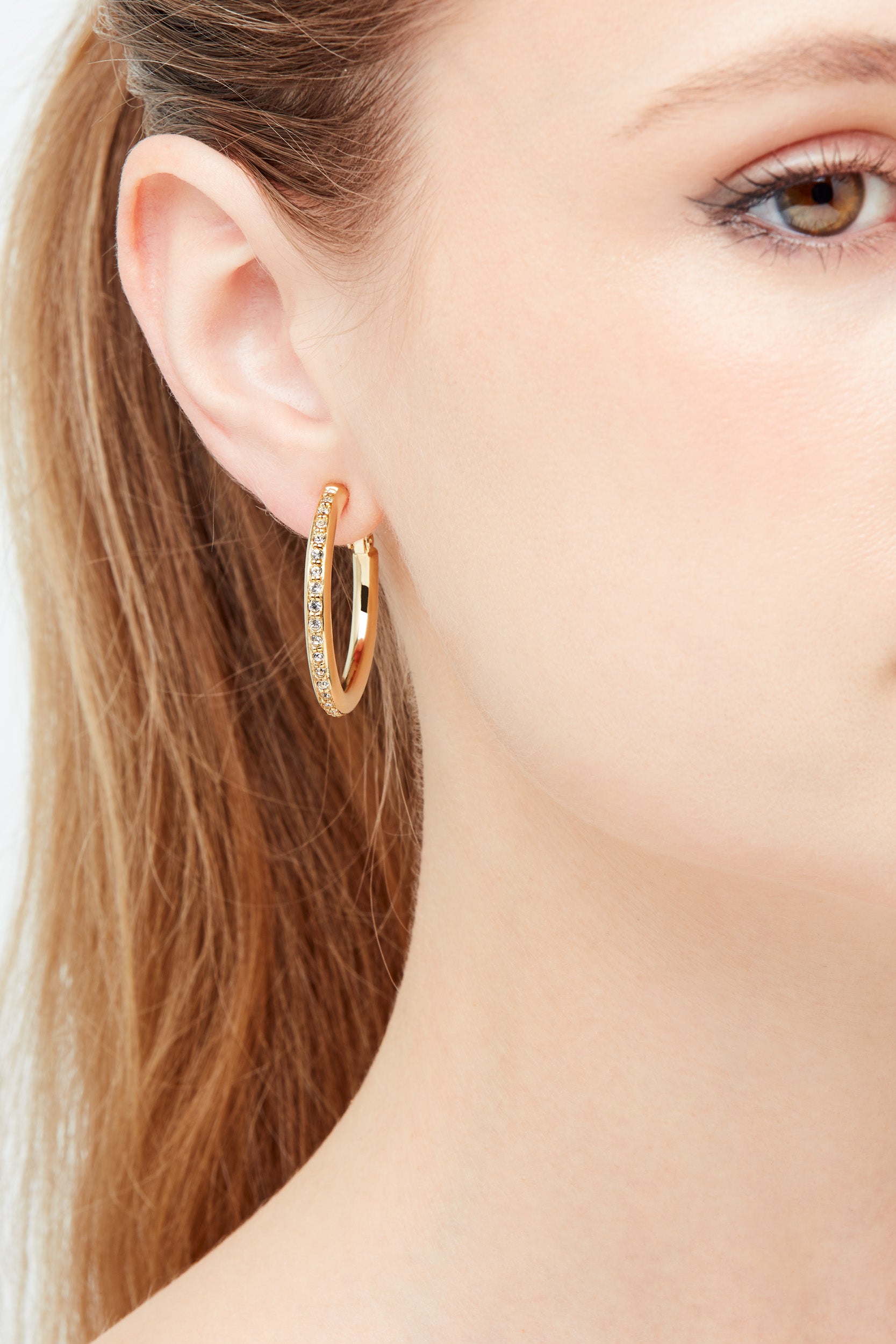 A close up shot of Emma Holland gold crystal clip earrings