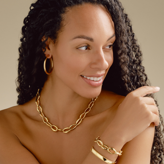 Woman wearing gold jewelry with 'NEW COLLECTION' text on a beige background