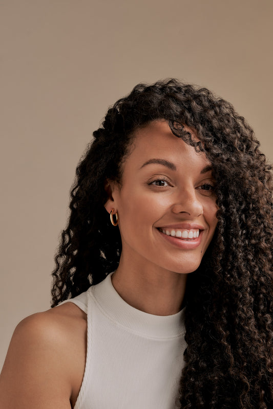 A model wearing gold hoop clip on earrings