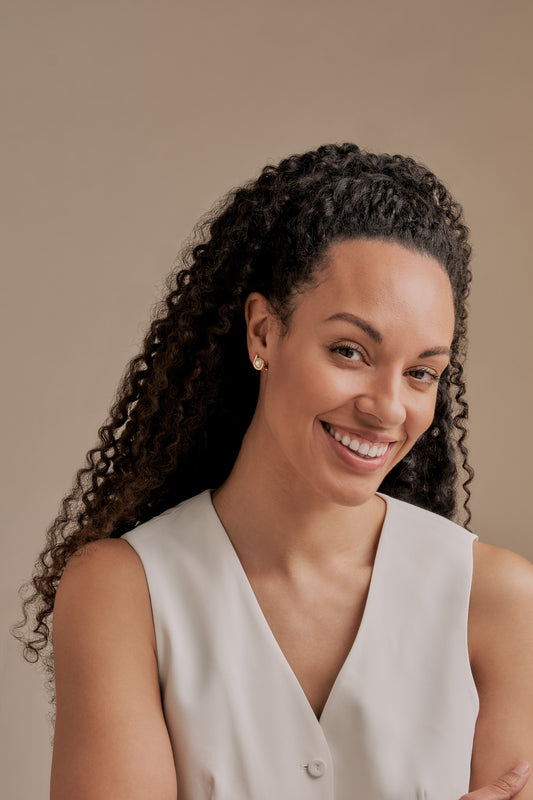 A model with Emma Holland gold pearl clip on earrings