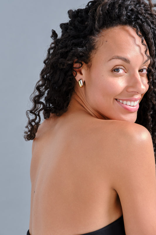 Model with gold and platinum curve clip earrings