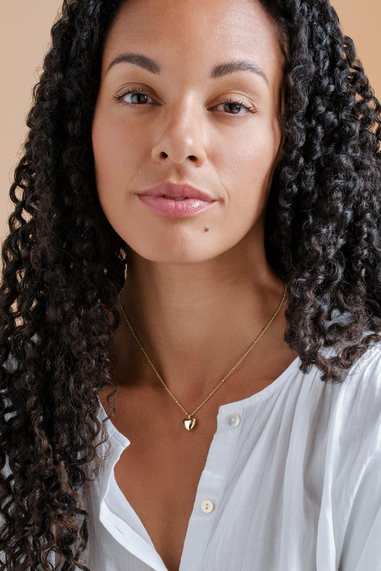 A model wearing gold heart pendant