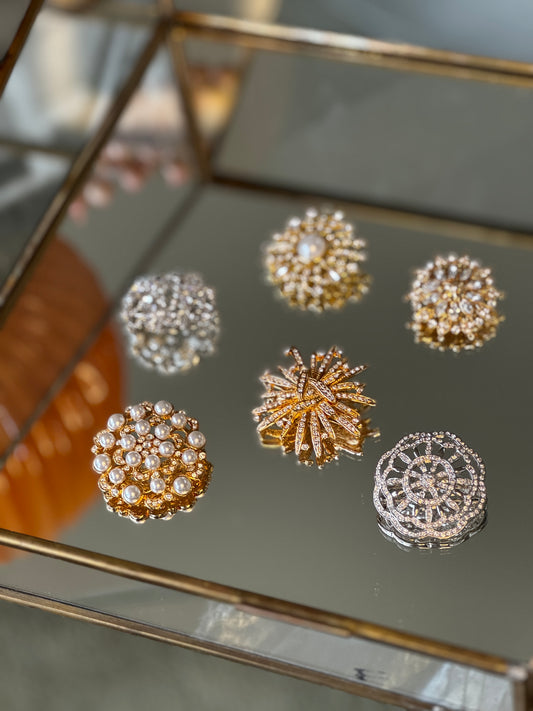 Set of gold and silver brooches on a reflective surface