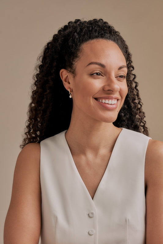 A model wearing Emma Holland Pearl Charm Earrings