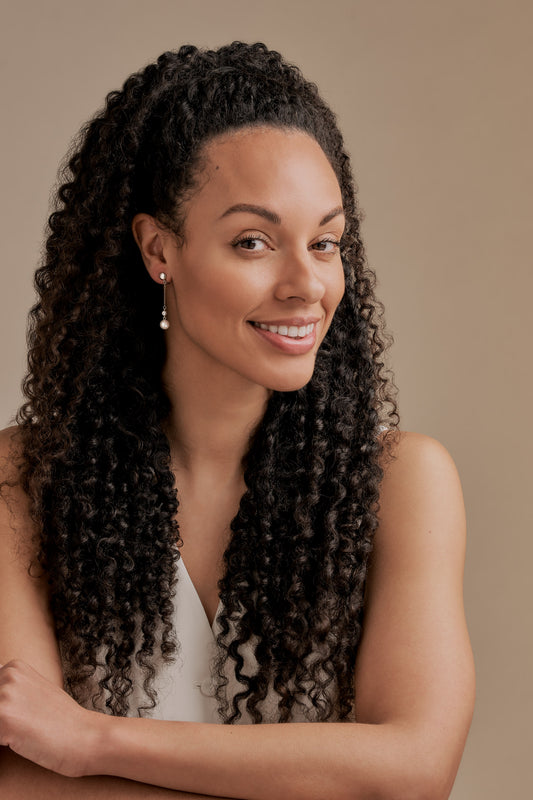 A model wearing pearl drop clip on earrings