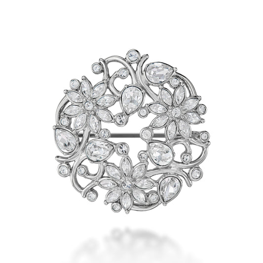 Silver brooch with floral design and clear stones on a white background
