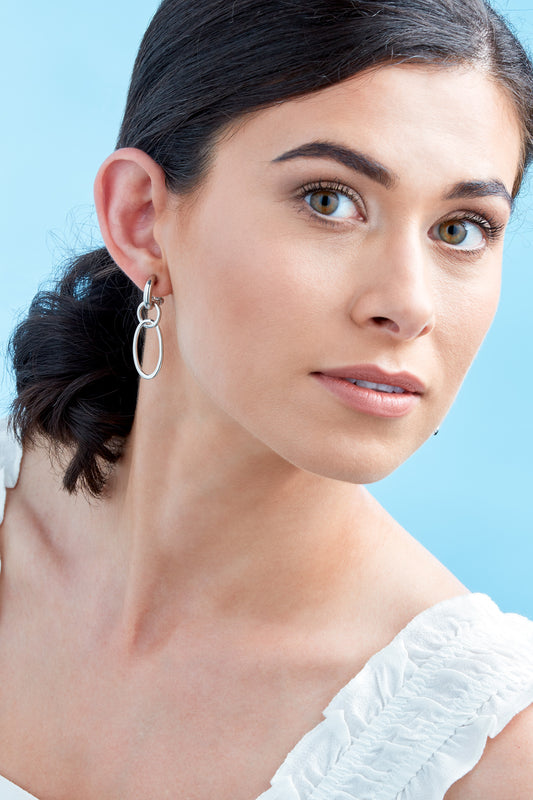A model wearing silver hoop clip on earrings