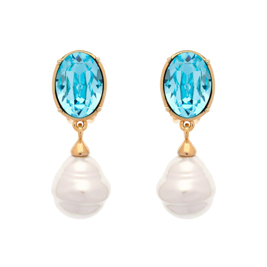 A pair of gold drop earrings featuring oval-cut light blue topaz stones and hanging baroque white pearls, set against a plain white background.