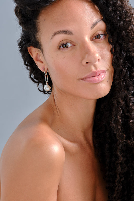 A model wearing baroque pearl clip on earrings