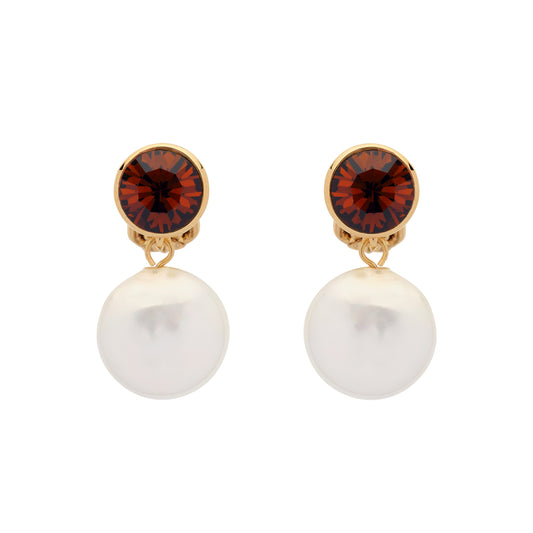 Pair of earrings with red gemstones and pearl-like bottoms on a white background