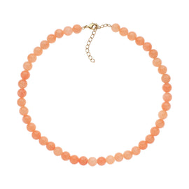 Peach-colored beaded necklace on a white background