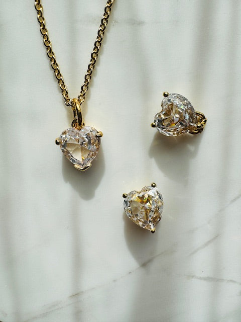 Heart-shaped diamond jewelry set on a marble surface