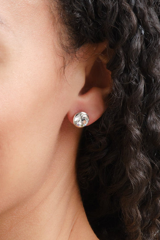 A model wearing gold solitaire crystal stud earrings