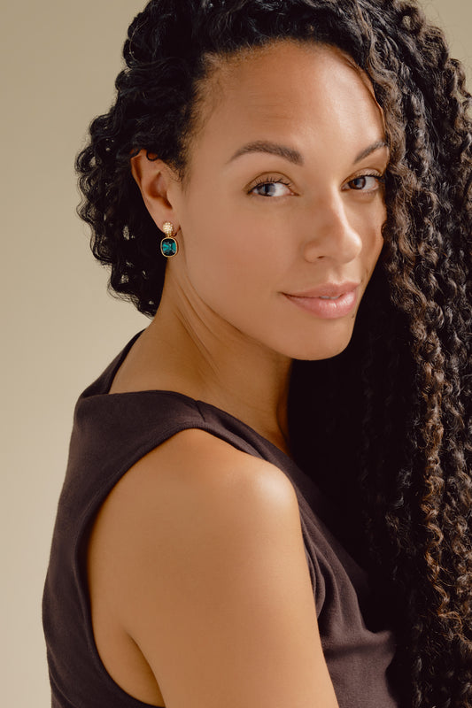 A model wearing emerald crystal drop clip earrings