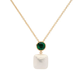 Gold necklace with a green gemstone and white pearl pendant on a white background