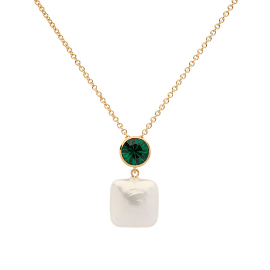 Gold necklace with a green gemstone and white pearl pendant on a white background