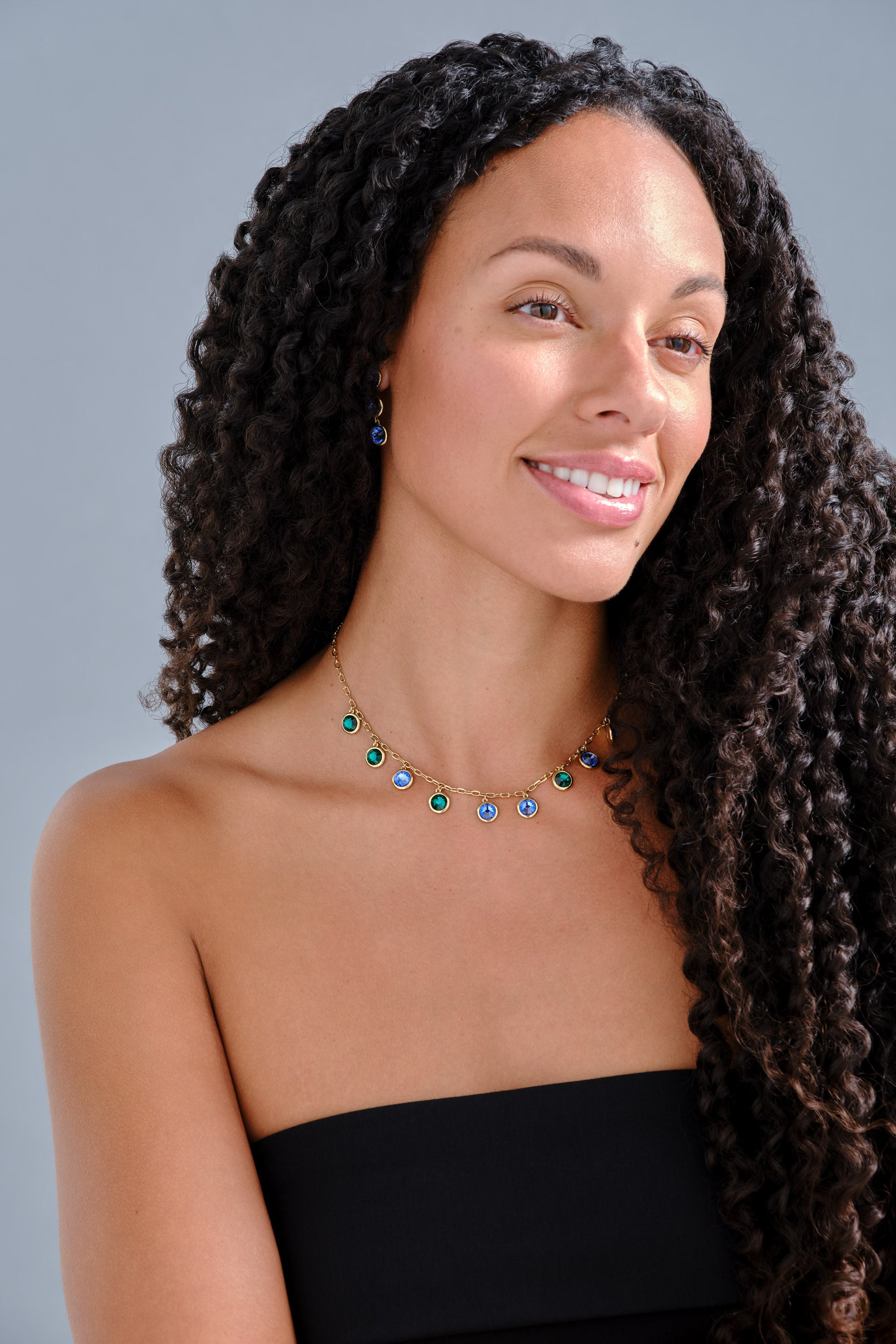 Model with green and purple crystal necklace