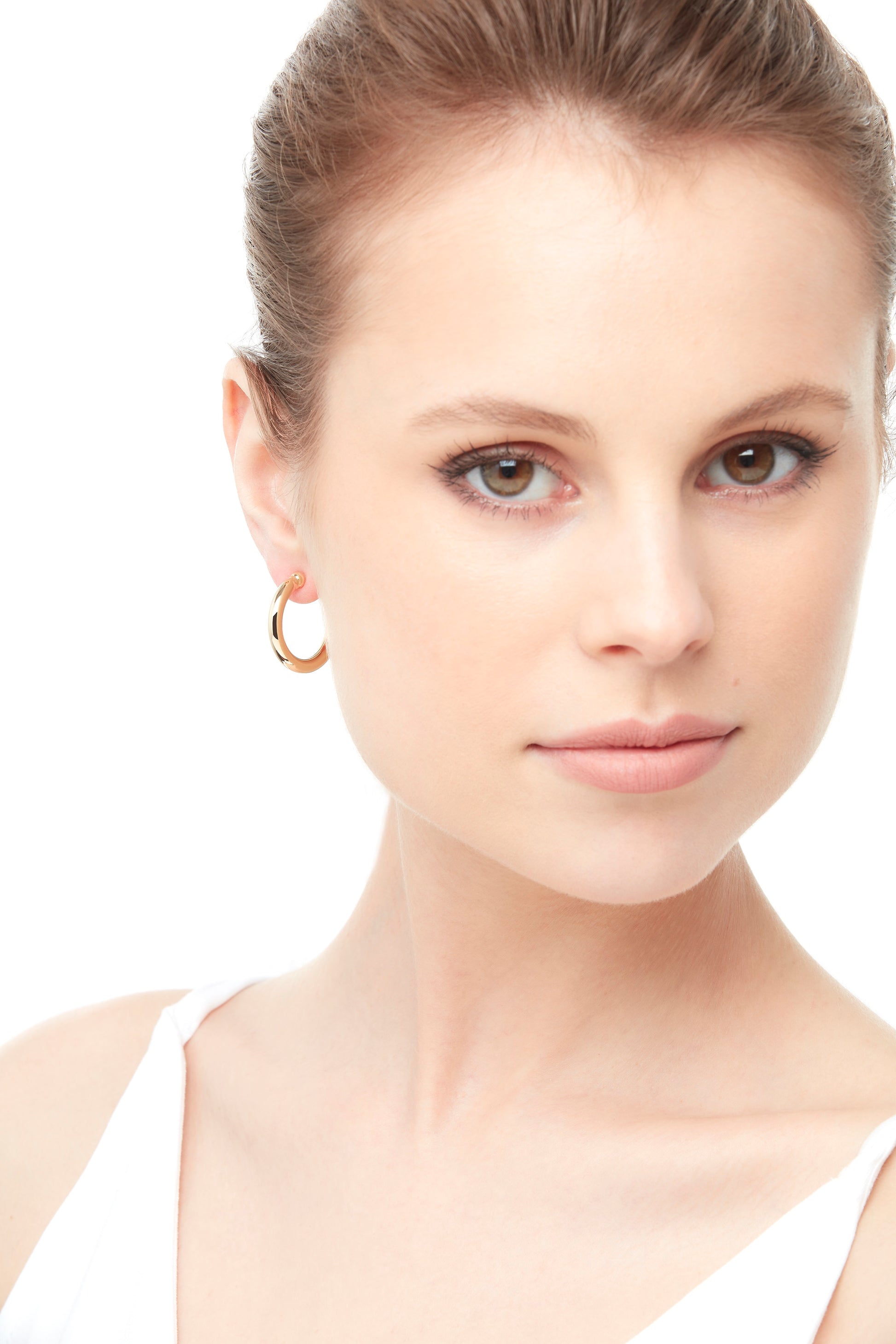 A model wearing gold plated hoop clip on earrings