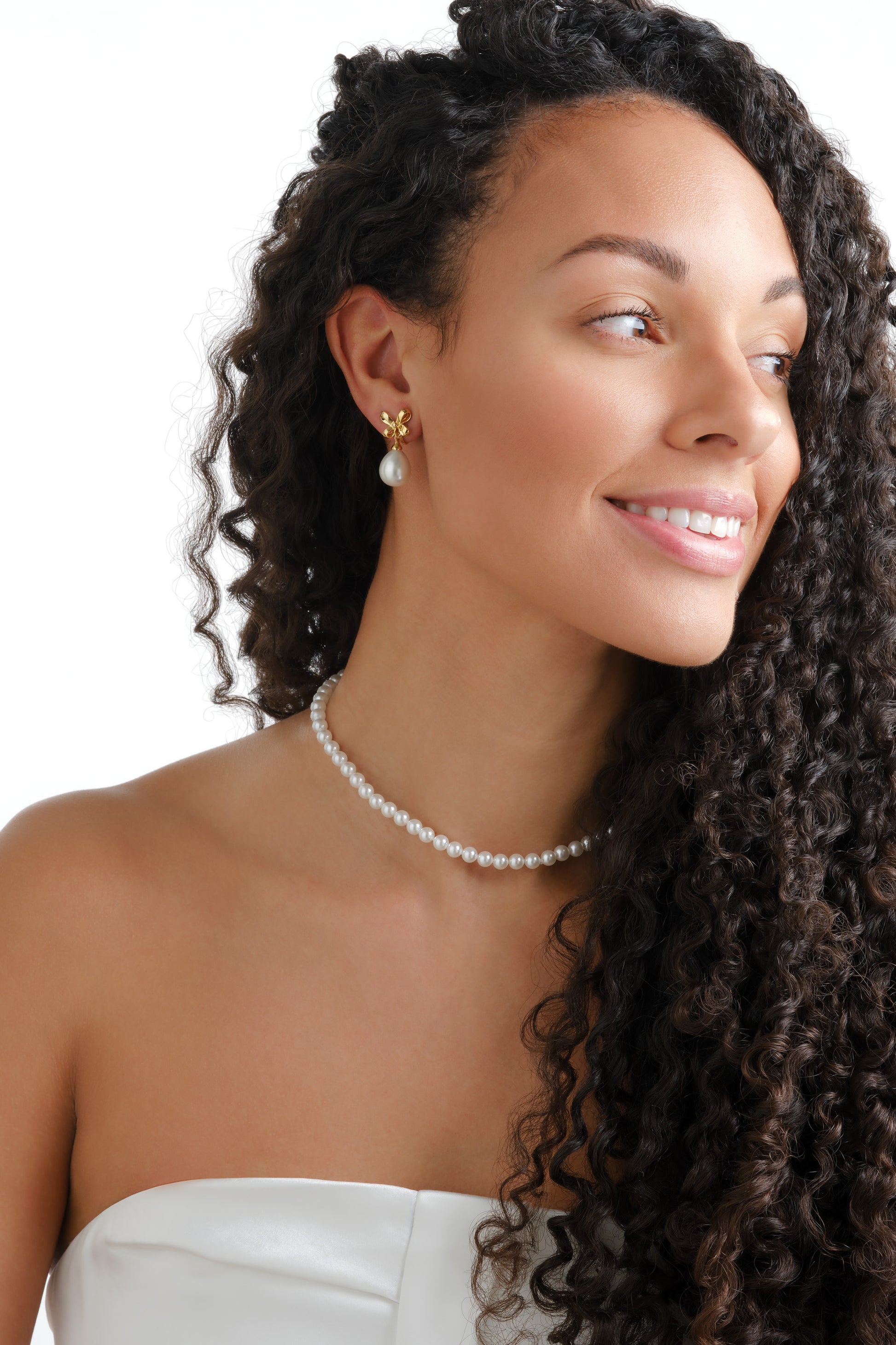 Model wearing gold bow and pearl clip earrings