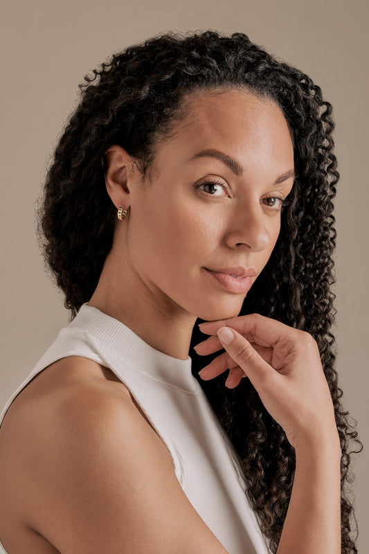 A model showing gold chain hoop pierced earrings