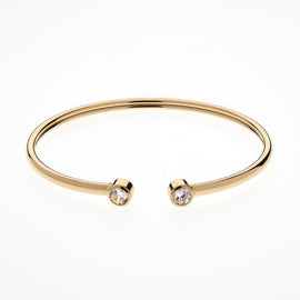 Gold bangle with two small diamonds on a white background