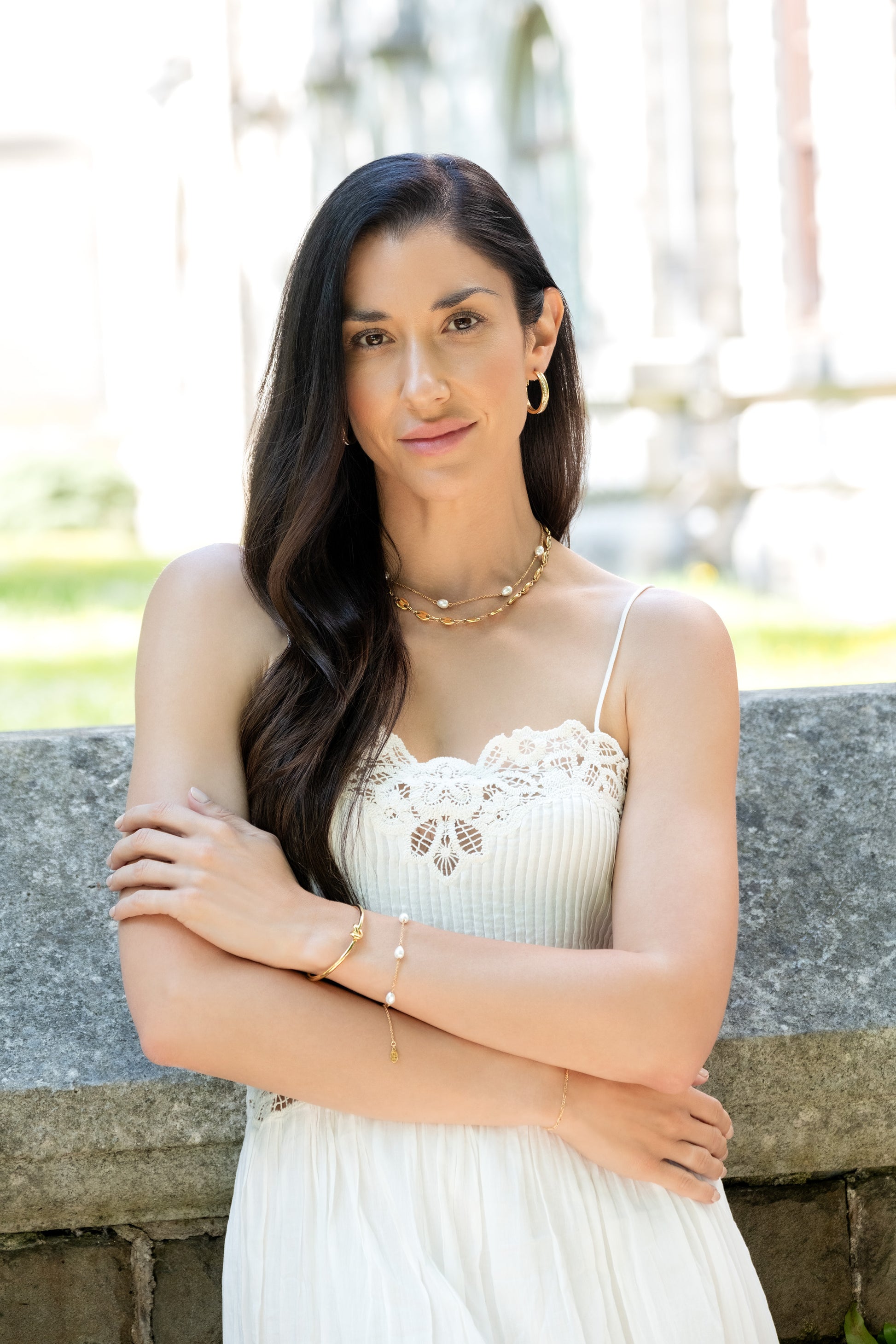 Woman in a white dress standing outdoors with a blurred background