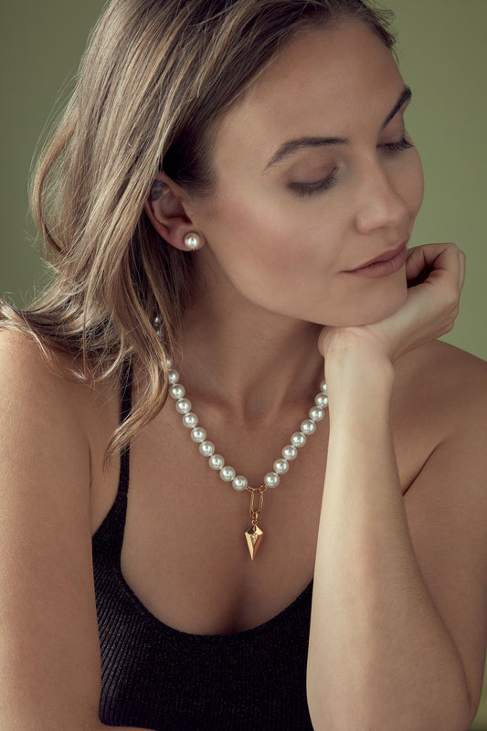 A model wearing Emma Holland Pearl and gold art deco charm necklace.