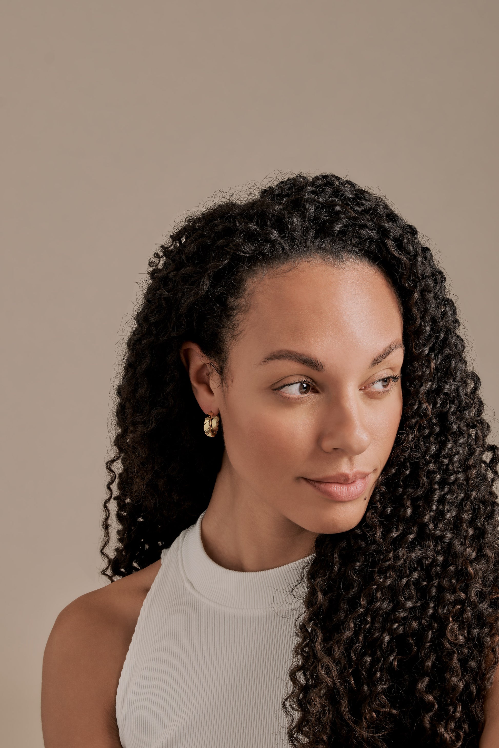 A model with gold plated hoop earrings