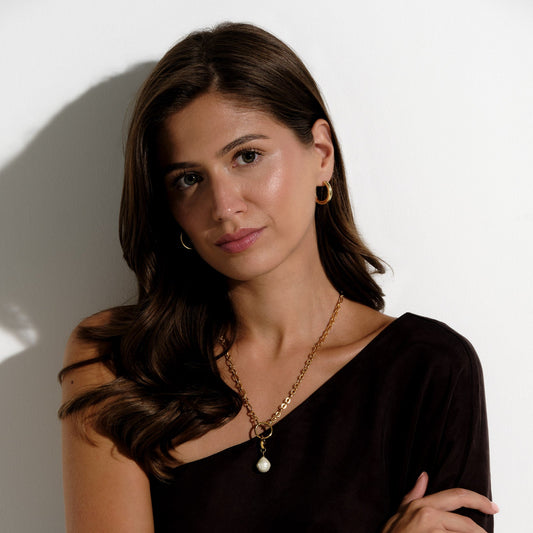 A model wearing gold polished hoop clip on earrings