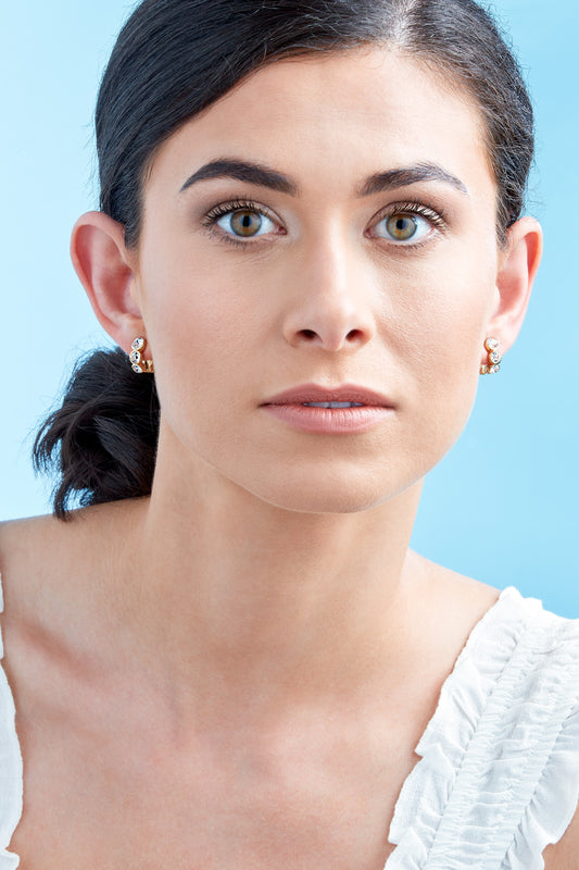 A model wearing gold plated crystal clip on earrings