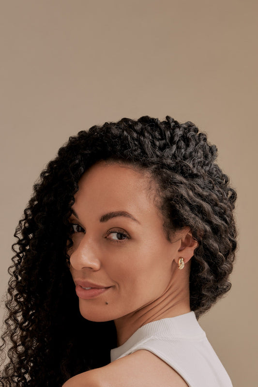 A model with Emma Holland Gold crystal twist clip earrings