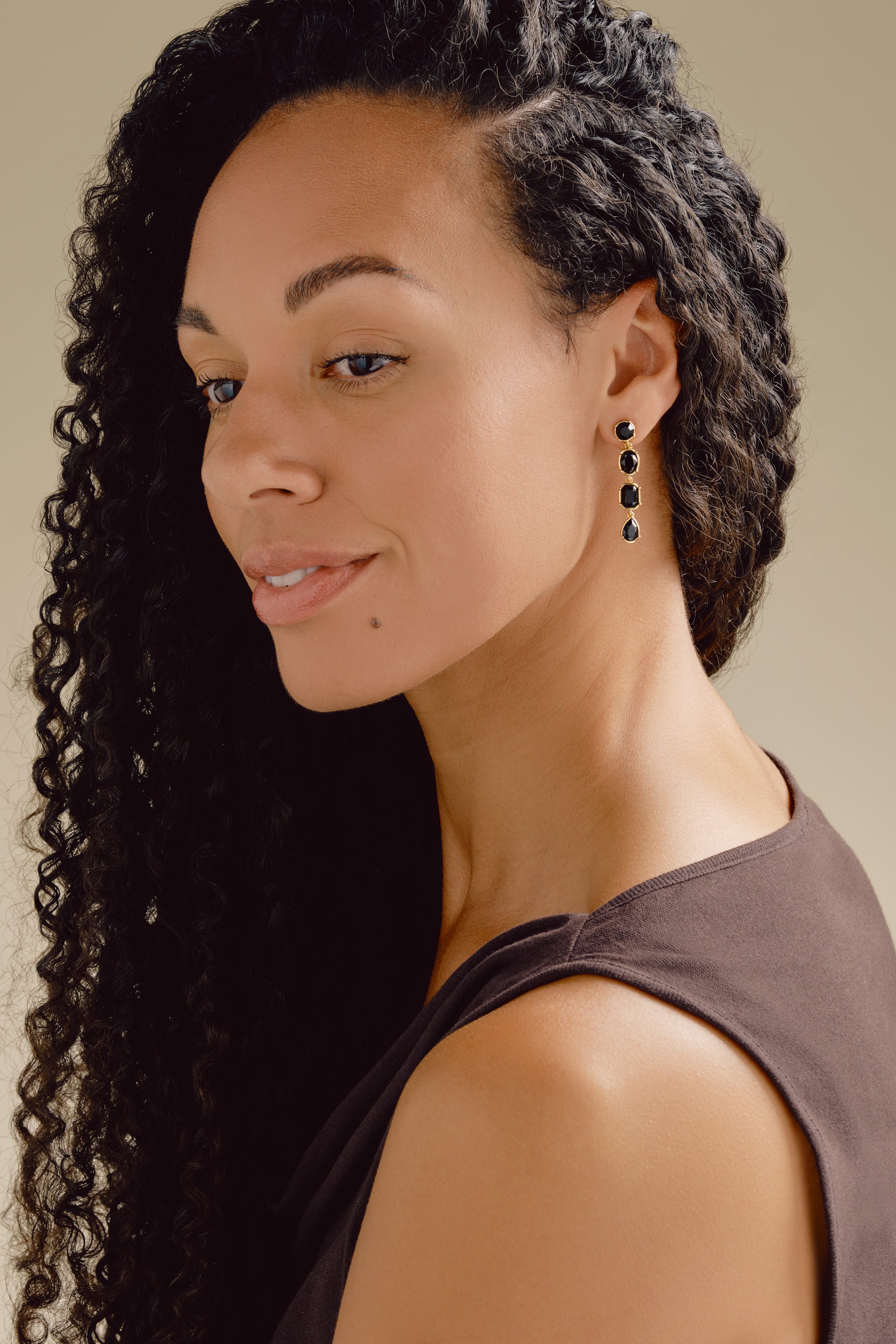 A model wearing black crystal clip on earrings
