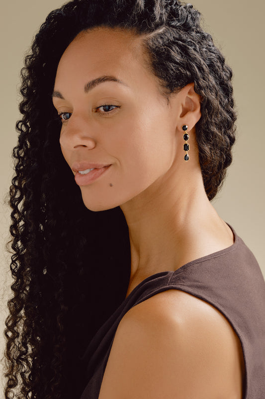A model wearing black crystal clip on earrings