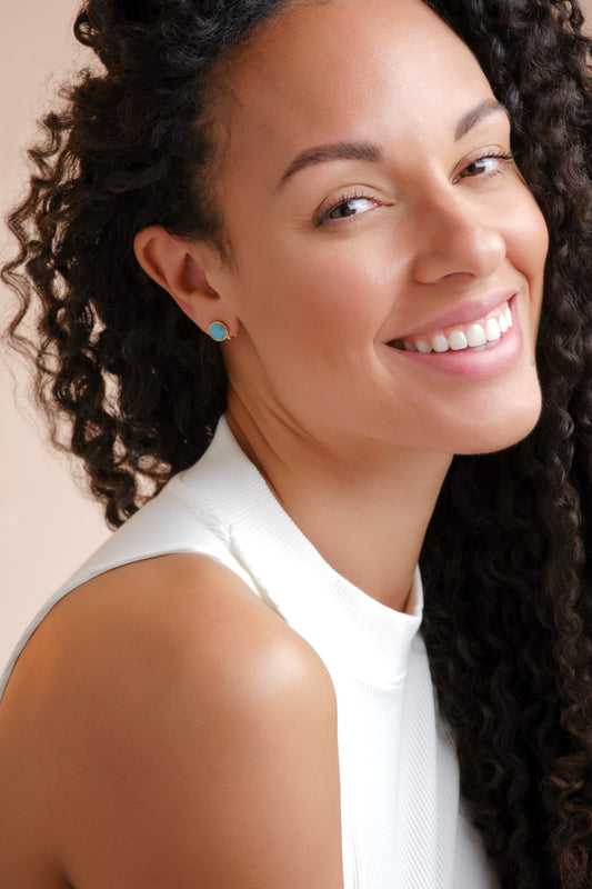 A model wearing turquoise stud earrings