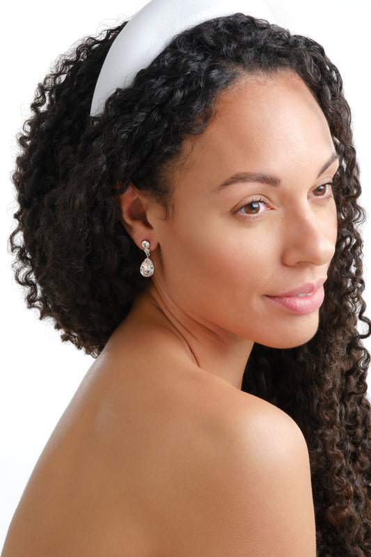 A model wearing platinum crystal teardrop earrings.