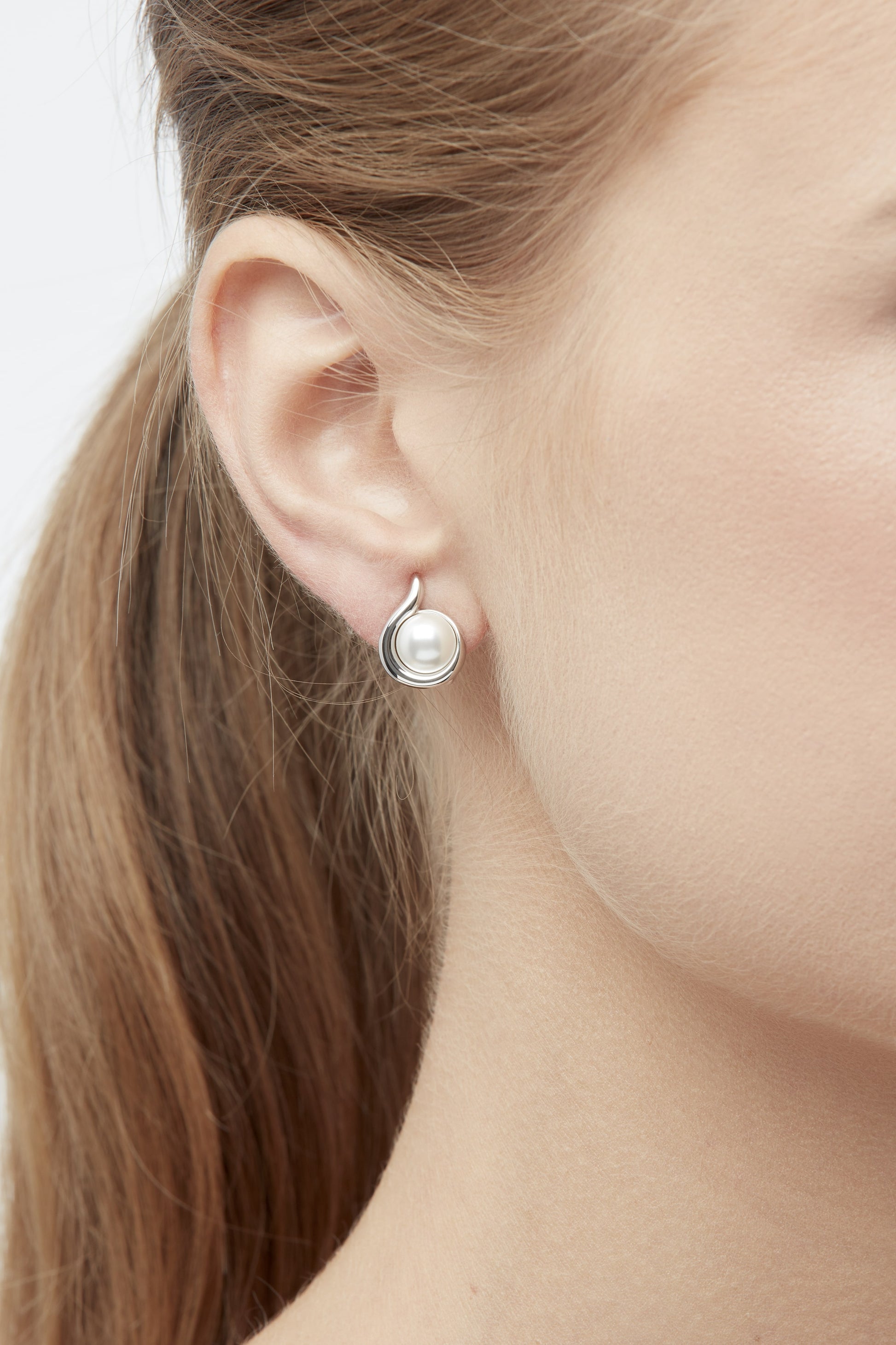 A close up shot of platinum pearl curl clip on earrings