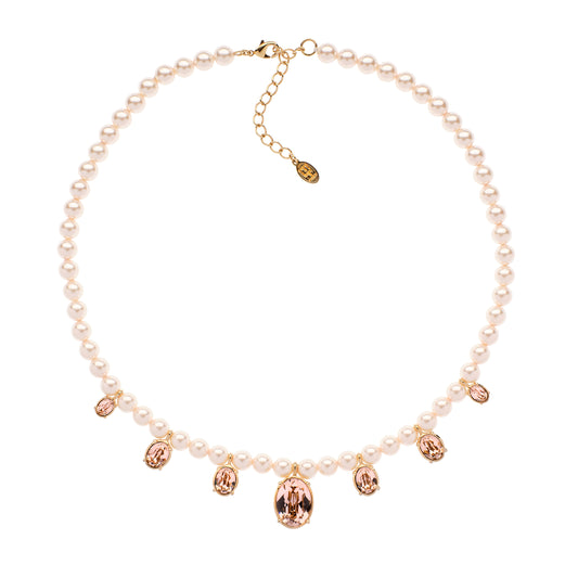 Pearl necklace with rose gold crystal charms on a white background