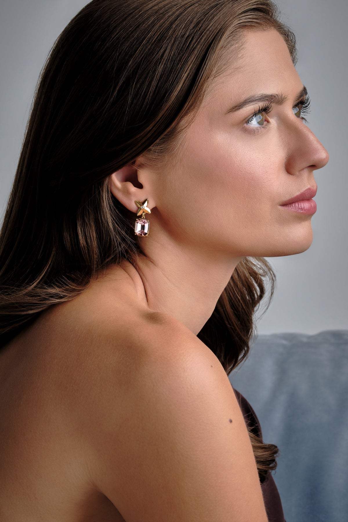 A model wearing pink crystal flower clip on earrings