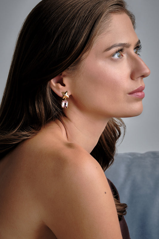 A model wearing pink crystal flower clip on earrings