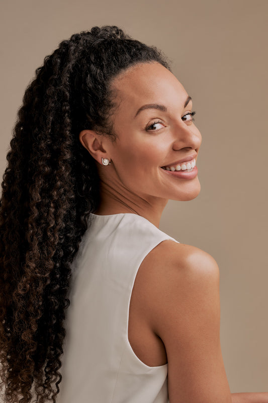 A model wearing silver and pearl clip on earrings