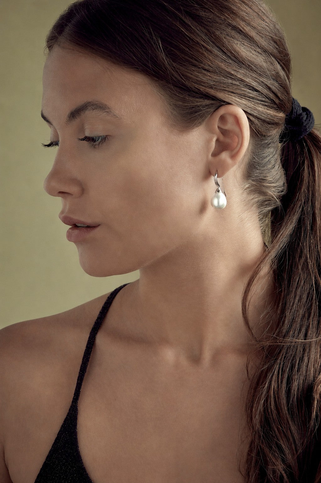 Close-up of a woman wearing earrings with a neutral background