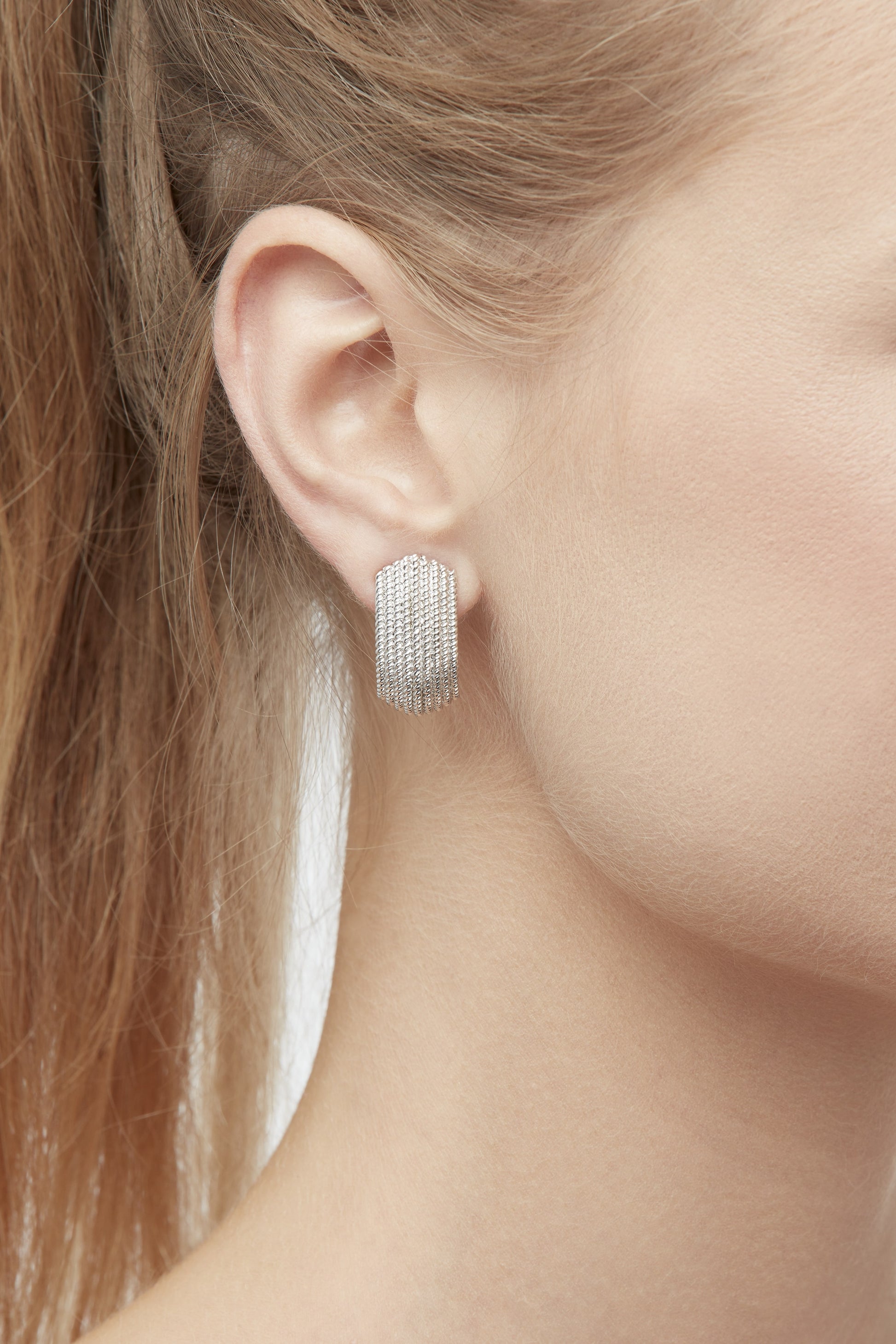 A large close up of Platinum textured clip on earrings